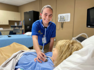 A Southeastern Illinois College nursing student listens to the heart of a patient.