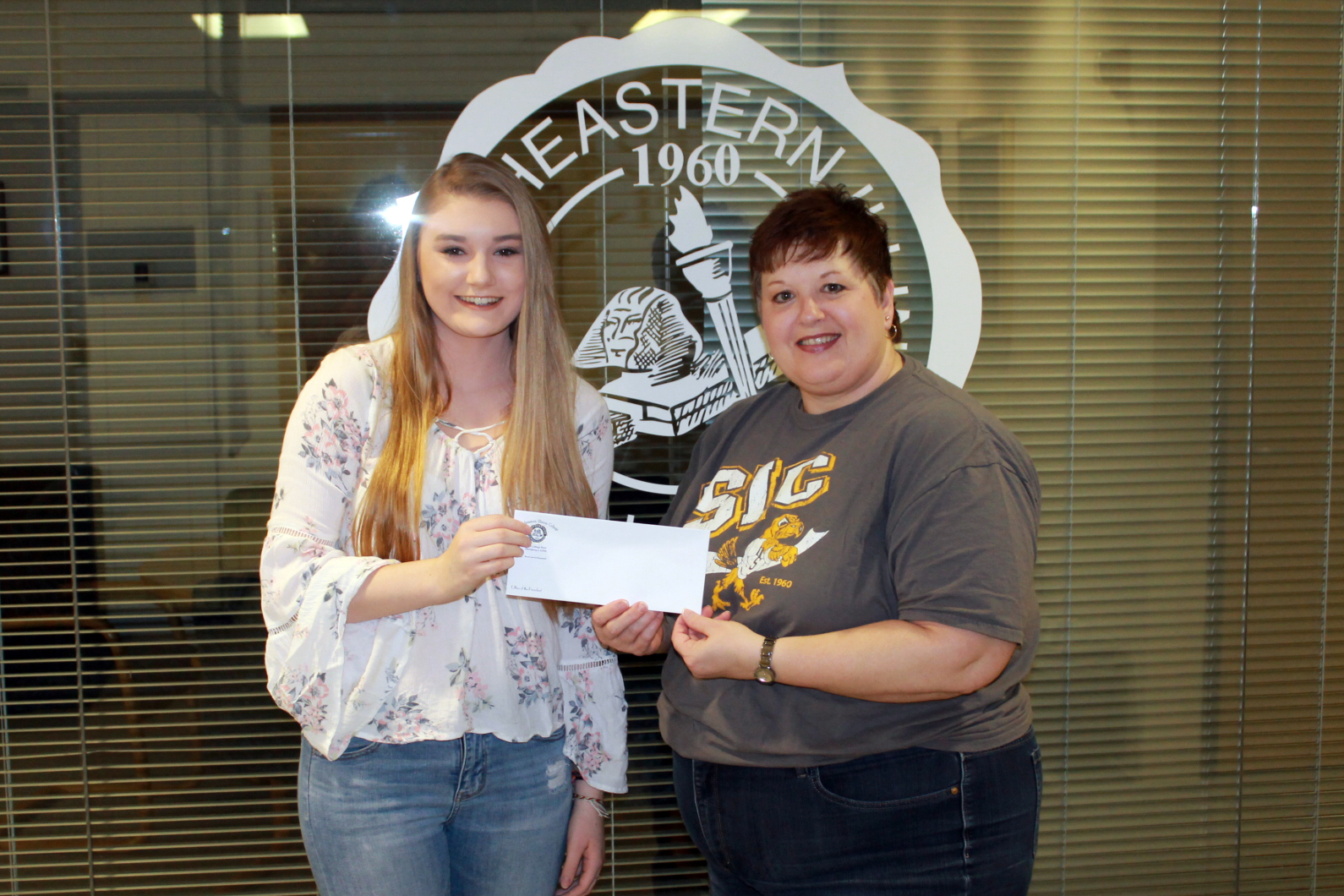 Olivia Matthews of Cave-In-Rock (left) receives a $50 check from Dr. Karen Weiss, SIC Vice President of Academic Affairs, for winning the 2018 Paul Simon Essay Contest at Southeastern Illinois College.