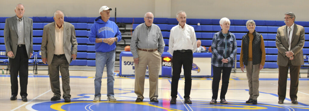 The 1962 and 1963 SIC Basketball teams gather at center court of Deaton Gymnasium.